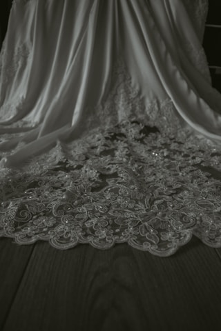 A close-up of elegant fabric textures and patterns displayed on a wooden table.