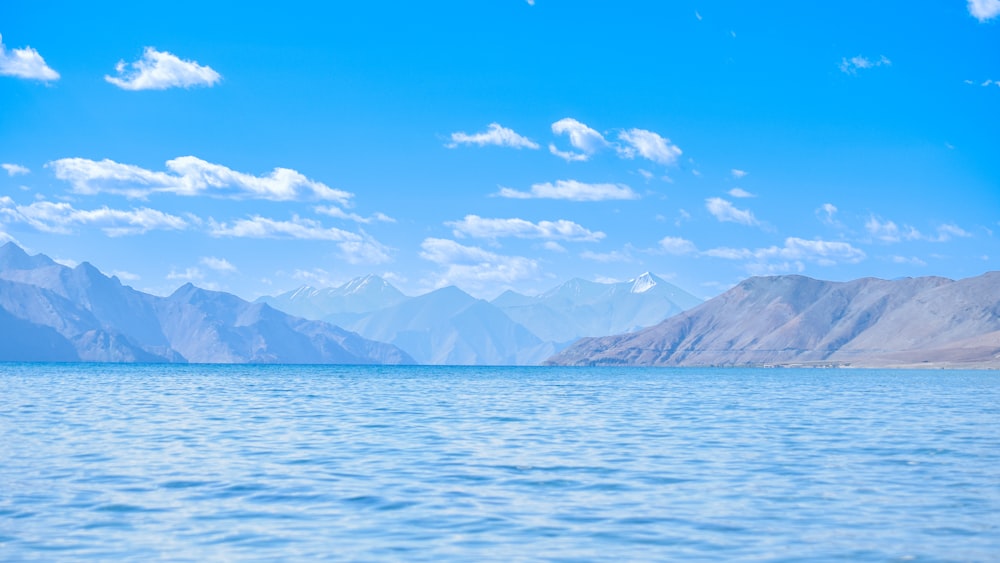 a large body of water with mountains in the background