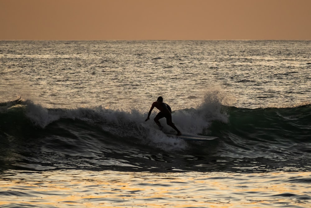 a man riding a wave on top of a surfboard