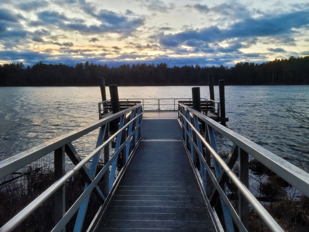 a dock on a body of water with a sunset in the background