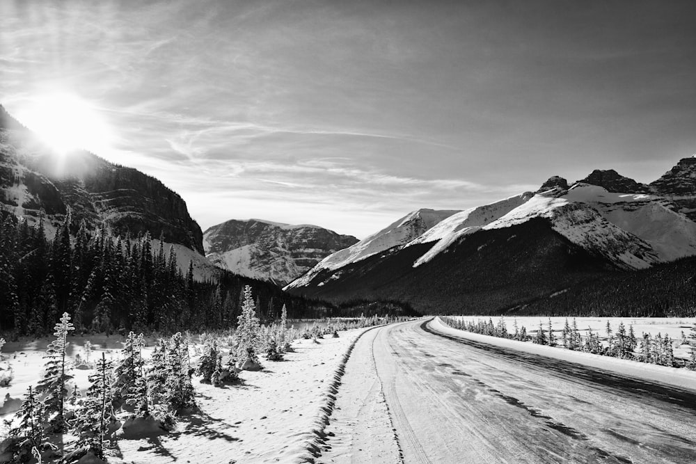 a black and white photo of a road in the mountains