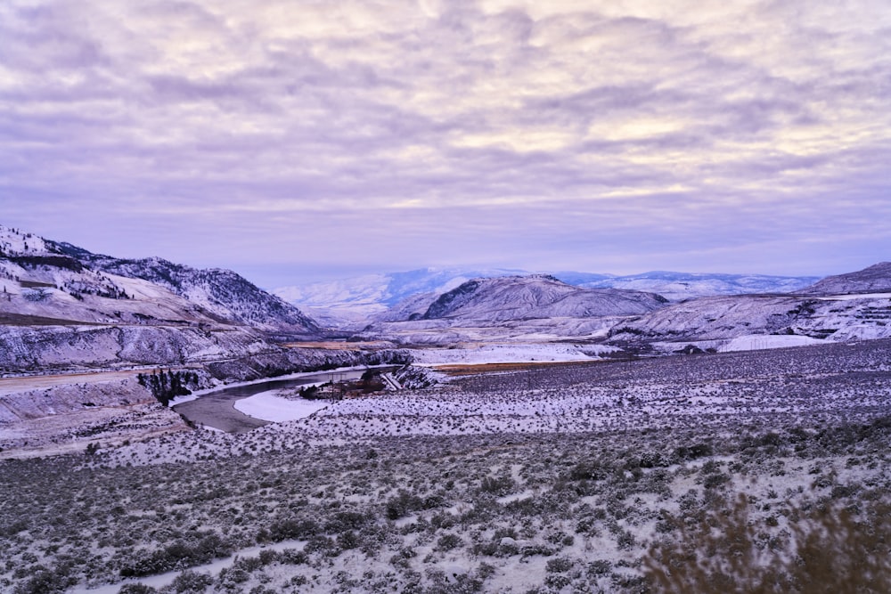 a snow covered landscape with mountains in the background