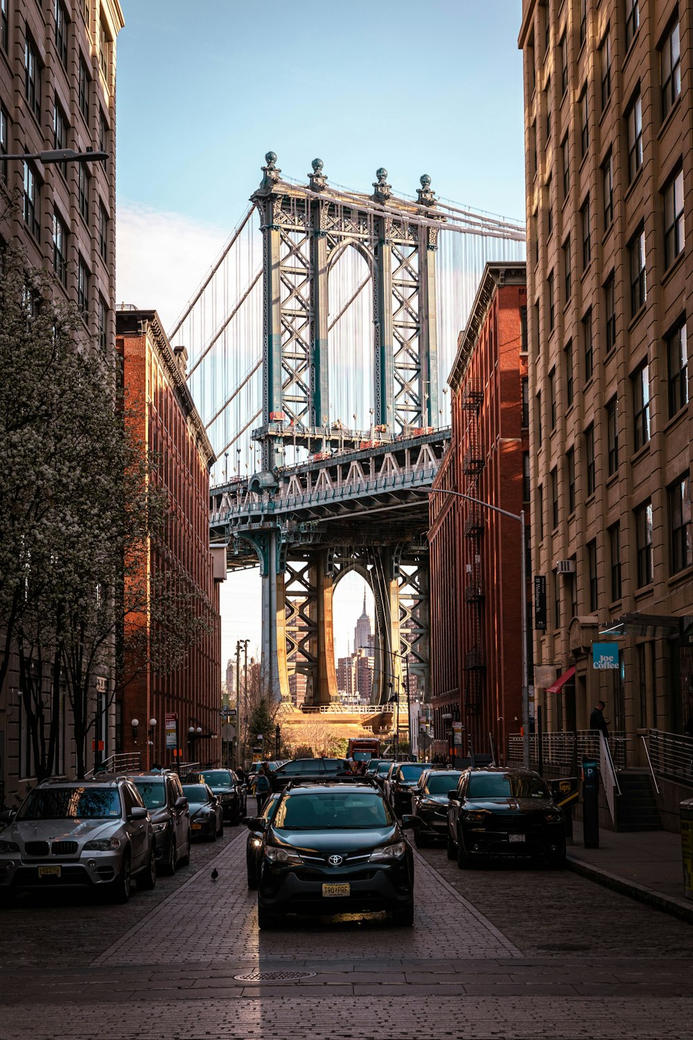 a city street with cars and a bridge in the background