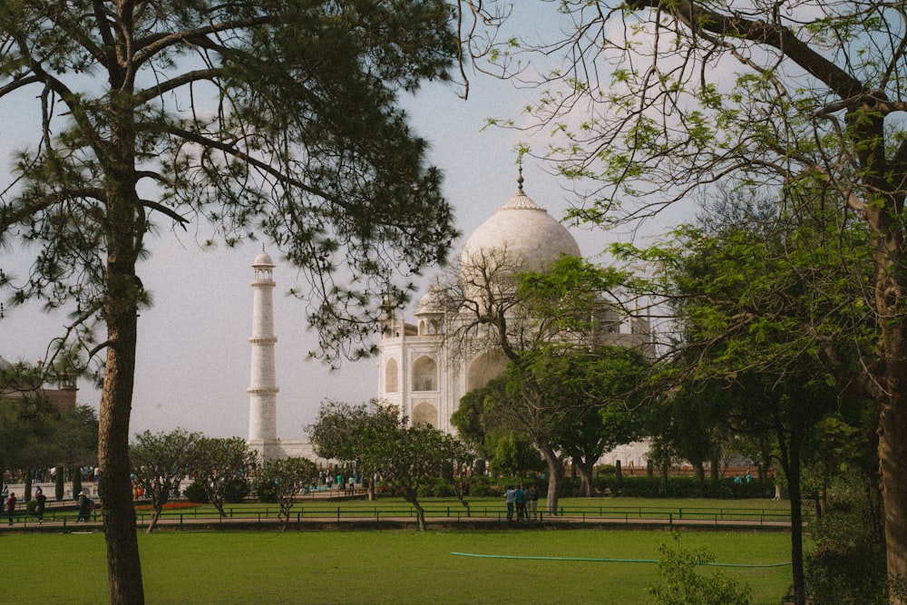 a large white building surrounded by trees and grass