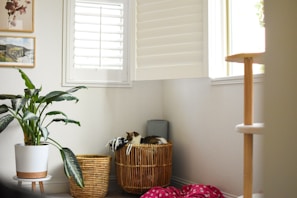 Sunlit corner of the studio with plants and finished handmade pieces arranged with soft blush pink accents