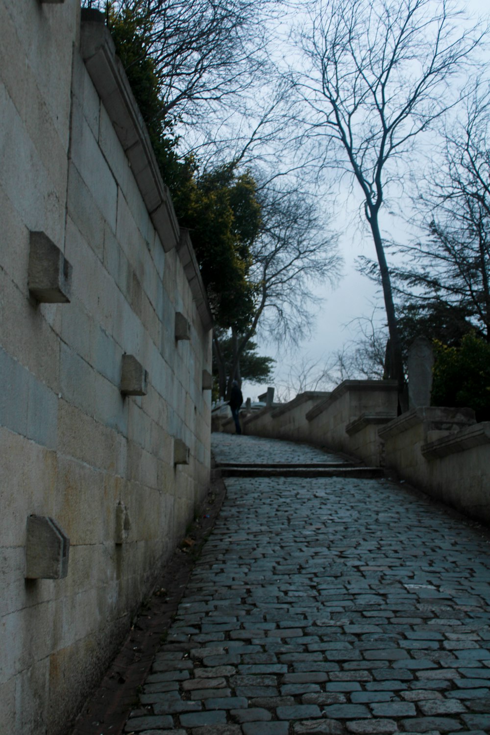 a cobblestone street with a clock on the wall