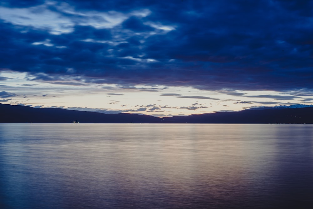 a large body of water under a cloudy sky