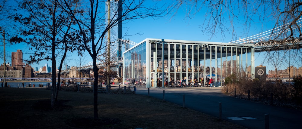a large glass building with a bridge in the background