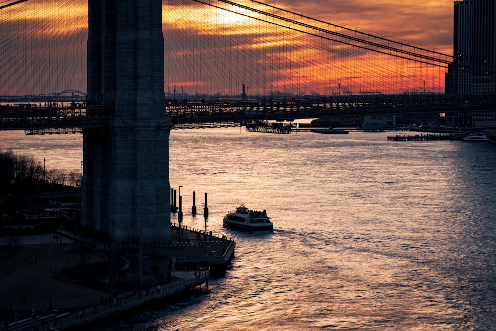 a boat traveling down a river under a bridge