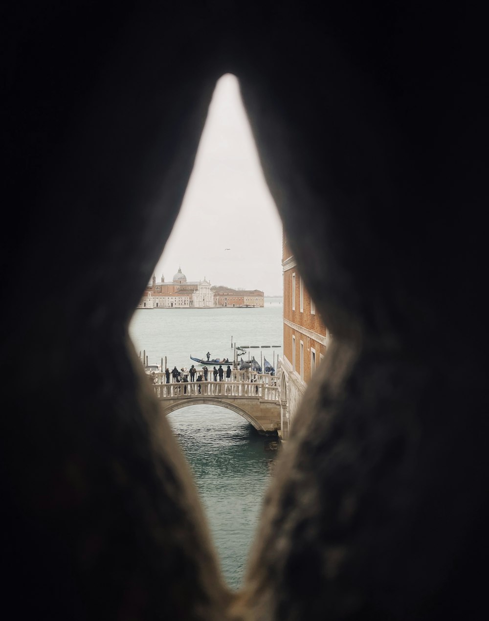 a view of a body of water through a hole in a rock