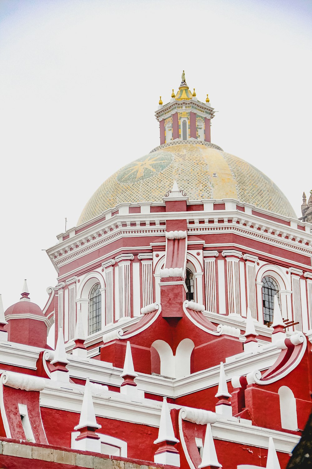 a red and white building with a gold dome