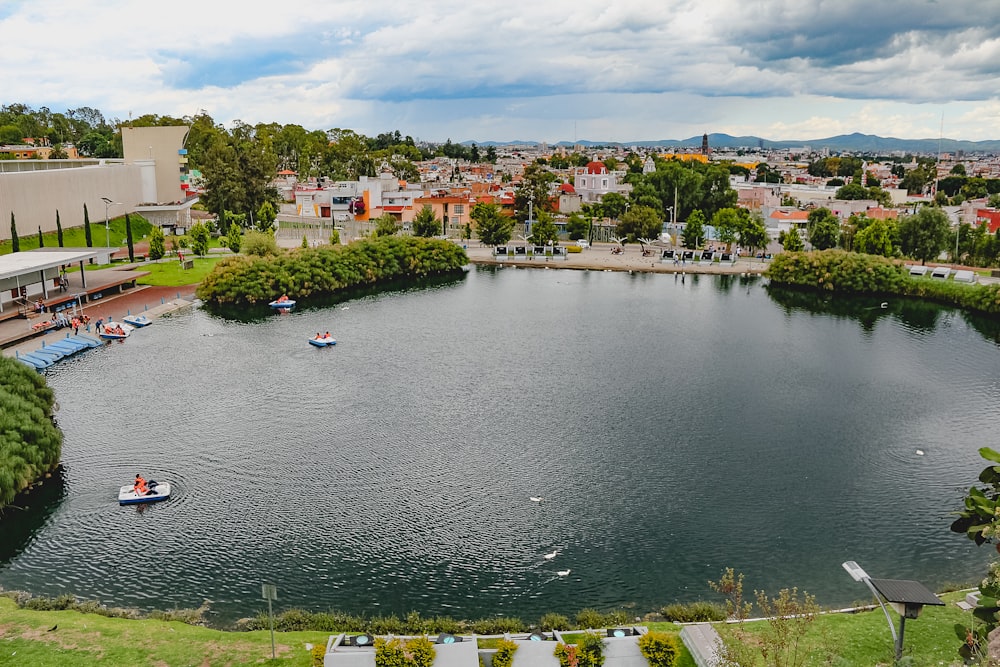 a lake surrounded by a city with boats in it