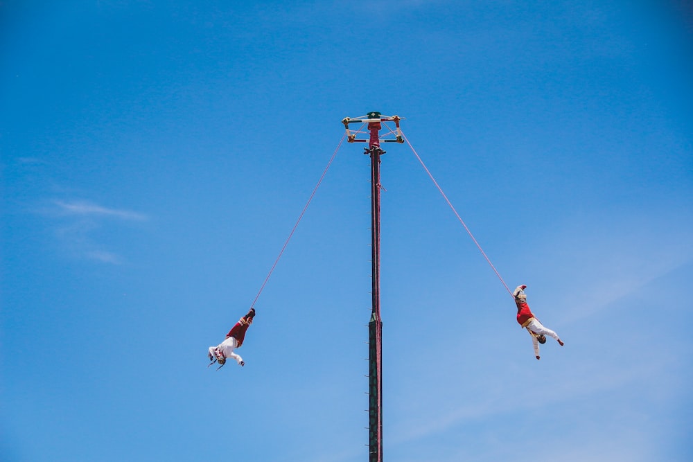 a couple of people that are on some kind of pole