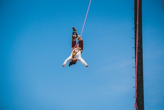 A vibrant aerial performer mid-flight during an outdoor event in La Rochelle.