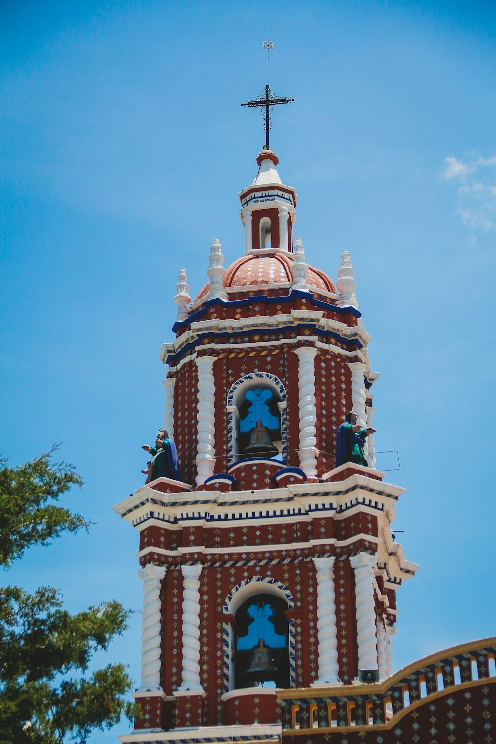 a tall clock tower with a cross on top