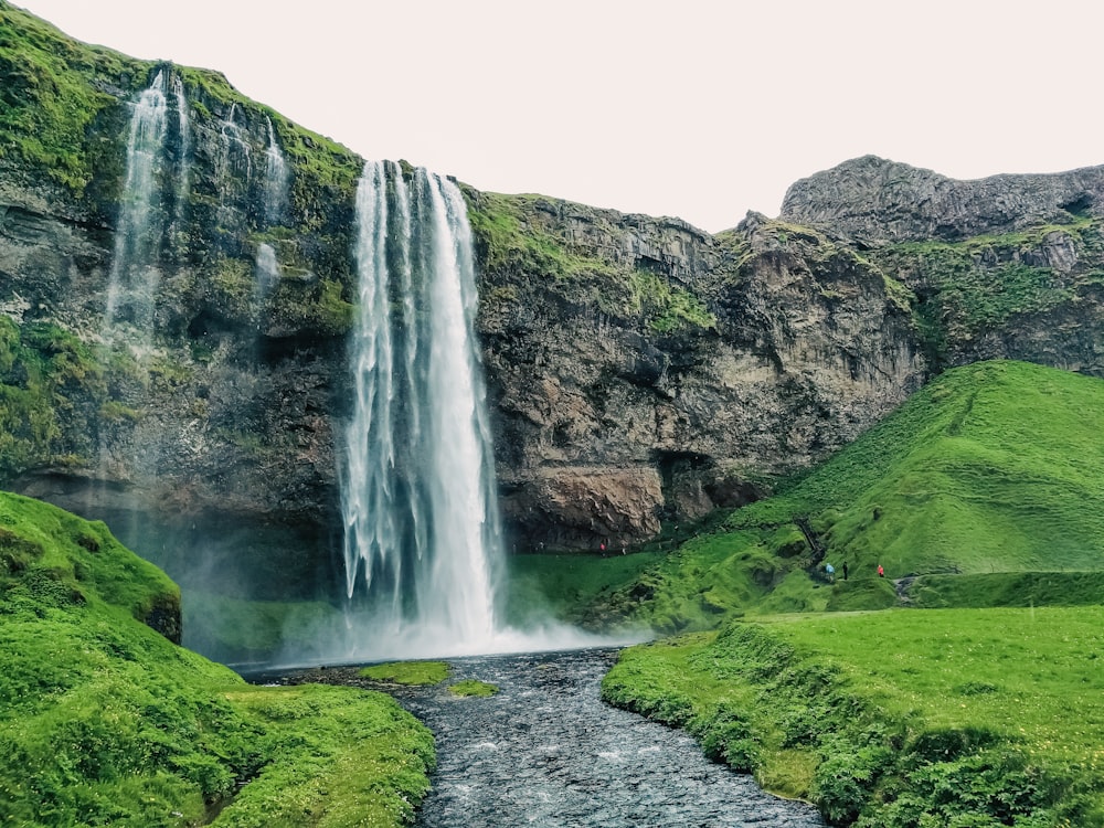 Una cascata nel mezzo di una valle verde e lussureggiante