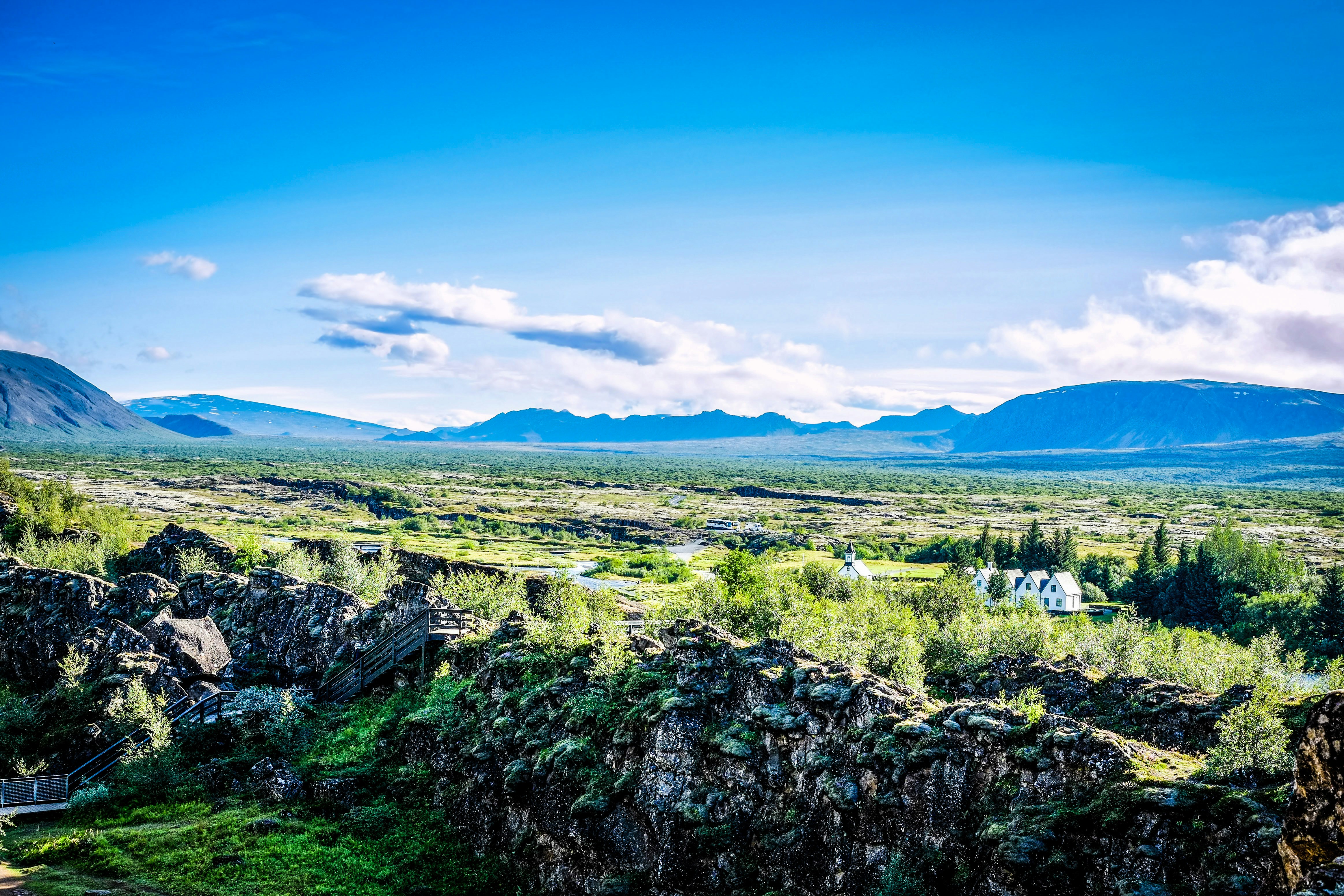 a scenic view of a valley with mountains in the background