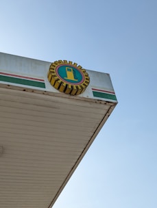 A vibrant petrol pump canopy featuring sturdy fabrication and sharp branding, set against a clear sky.