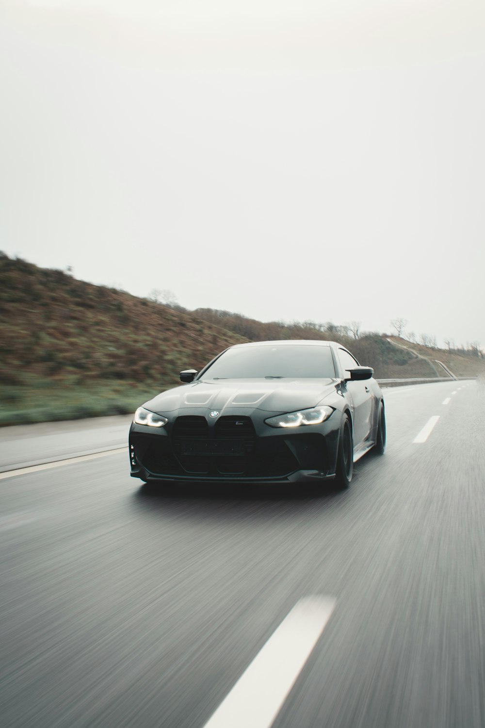 a black sports car driving down a highway