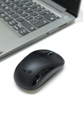 a computer mouse sitting next to a laptop