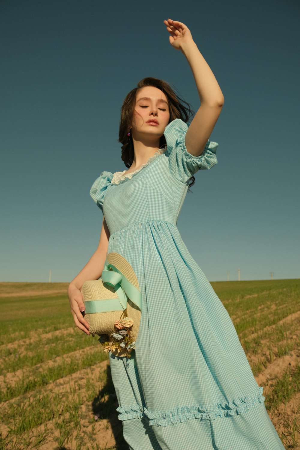 a woman in a blue dress standing in a field