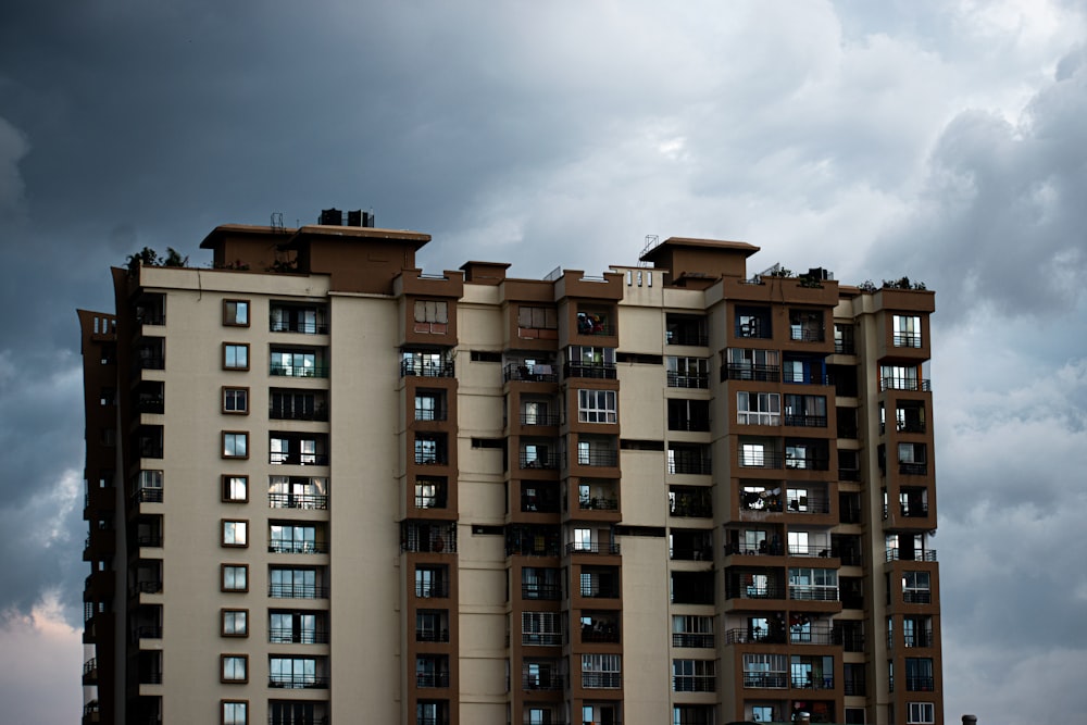 a tall building with many windows under a cloudy sky