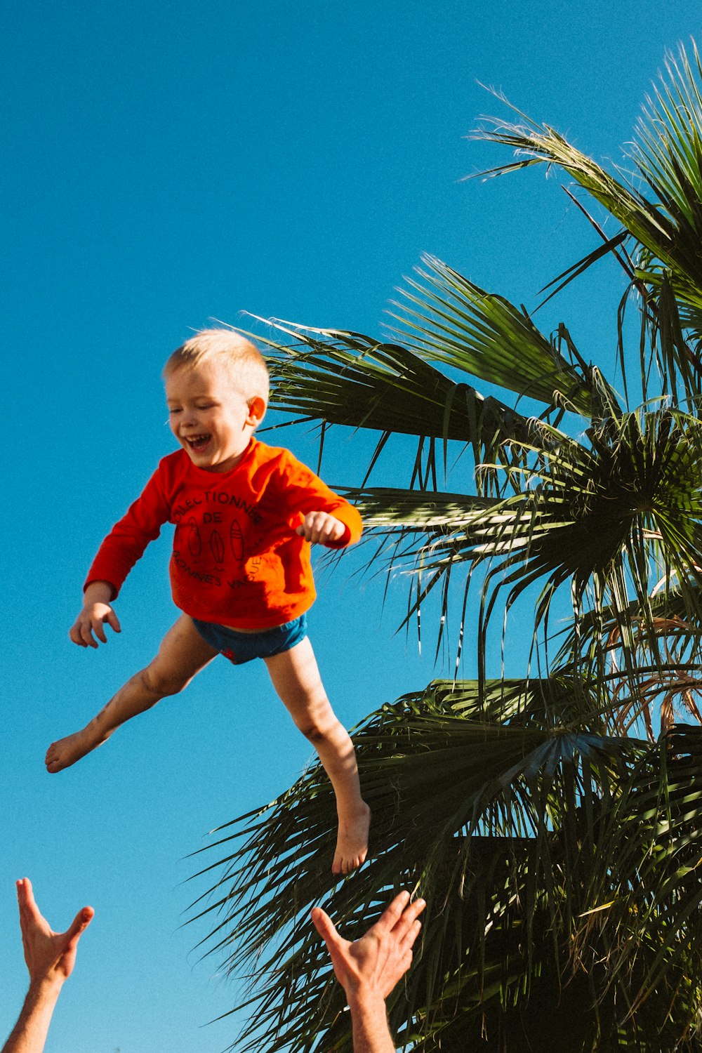 a man holding a baby up in the air