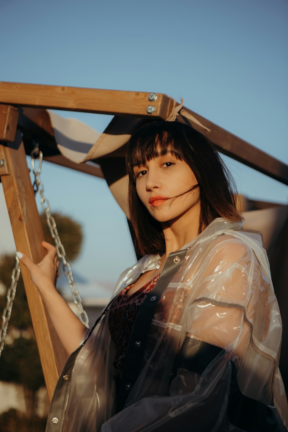 a woman in a plastic outfit holding onto a wooden frame