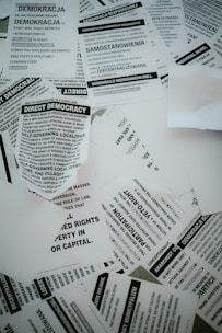 A collection of scattered flyers and papers with text related to concepts of democracy, rights, and anarchism. The papers are primarily in black and white and feature both English and Polish text.