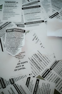 A collection of scattered flyers and papers with text related to concepts of democracy, rights, and anarchism. The papers are primarily in black and white and feature both English and Polish text.