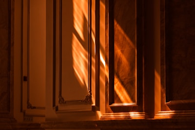 Sunlight casting shadows over the carved reliefs on a temple wall.