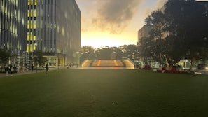 Evening lights illuminating the main academic building with students walking by.