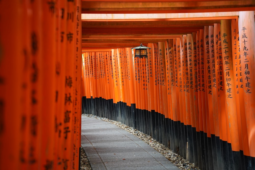 a walkway lined with orange and black columns