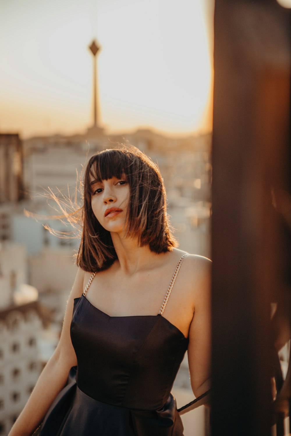 a woman in a black dress standing on a balcony