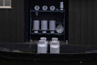 Fresh milk being collected in traditional metal containers on a rustic farm.