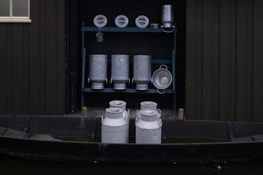 Fresh milk bottles and curd containers arranged neatly with a backdrop of a dairy farm.