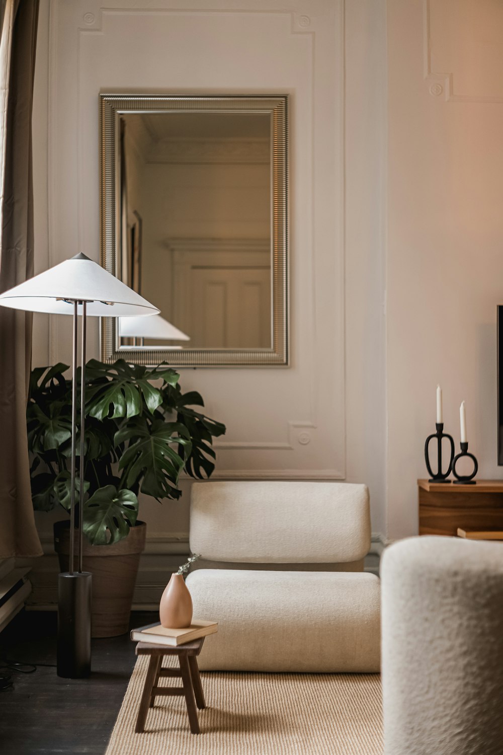 a living room filled with furniture and a large mirror