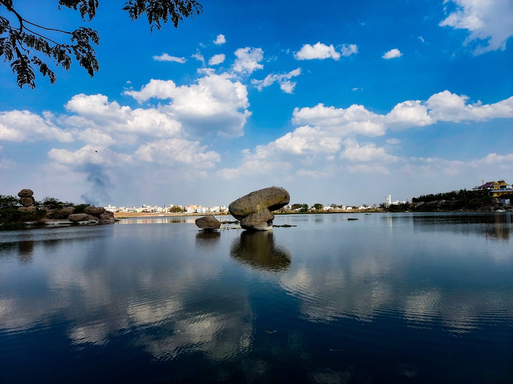a large rock sitting in the middle of a lake