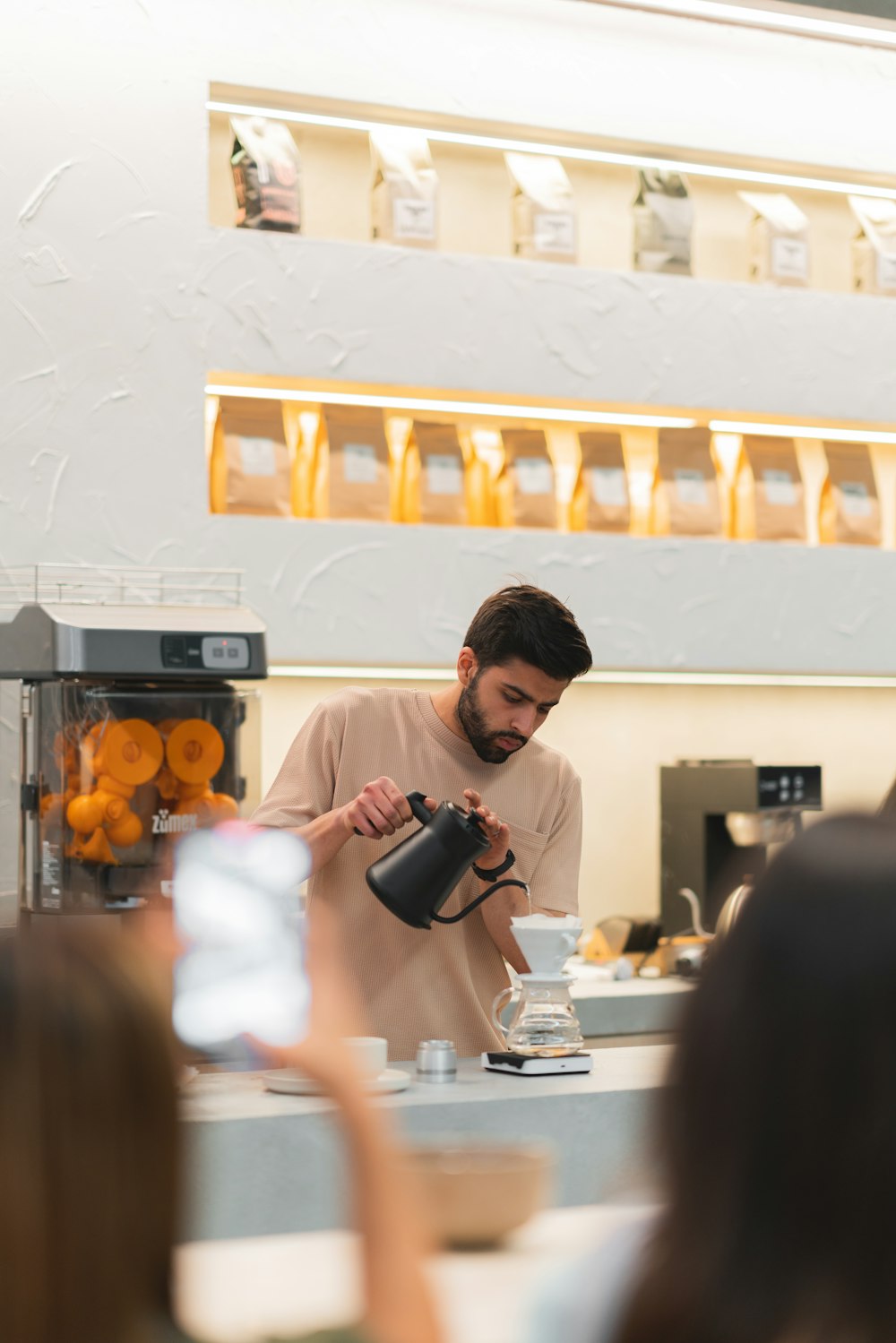 a man pouring a cup of coffee in front of a group of people