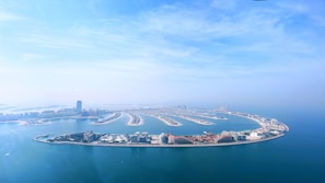 Aerial shot of Palm Jumeirah's palm-shaped island under twilight.
