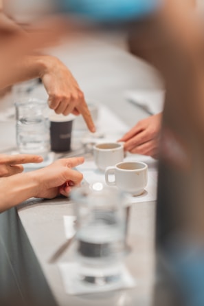 a group of people sitting at a table with cups of coffee