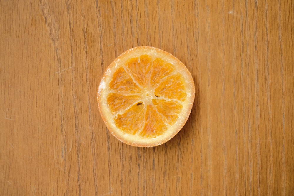 an orange cut in half on a wooden surface