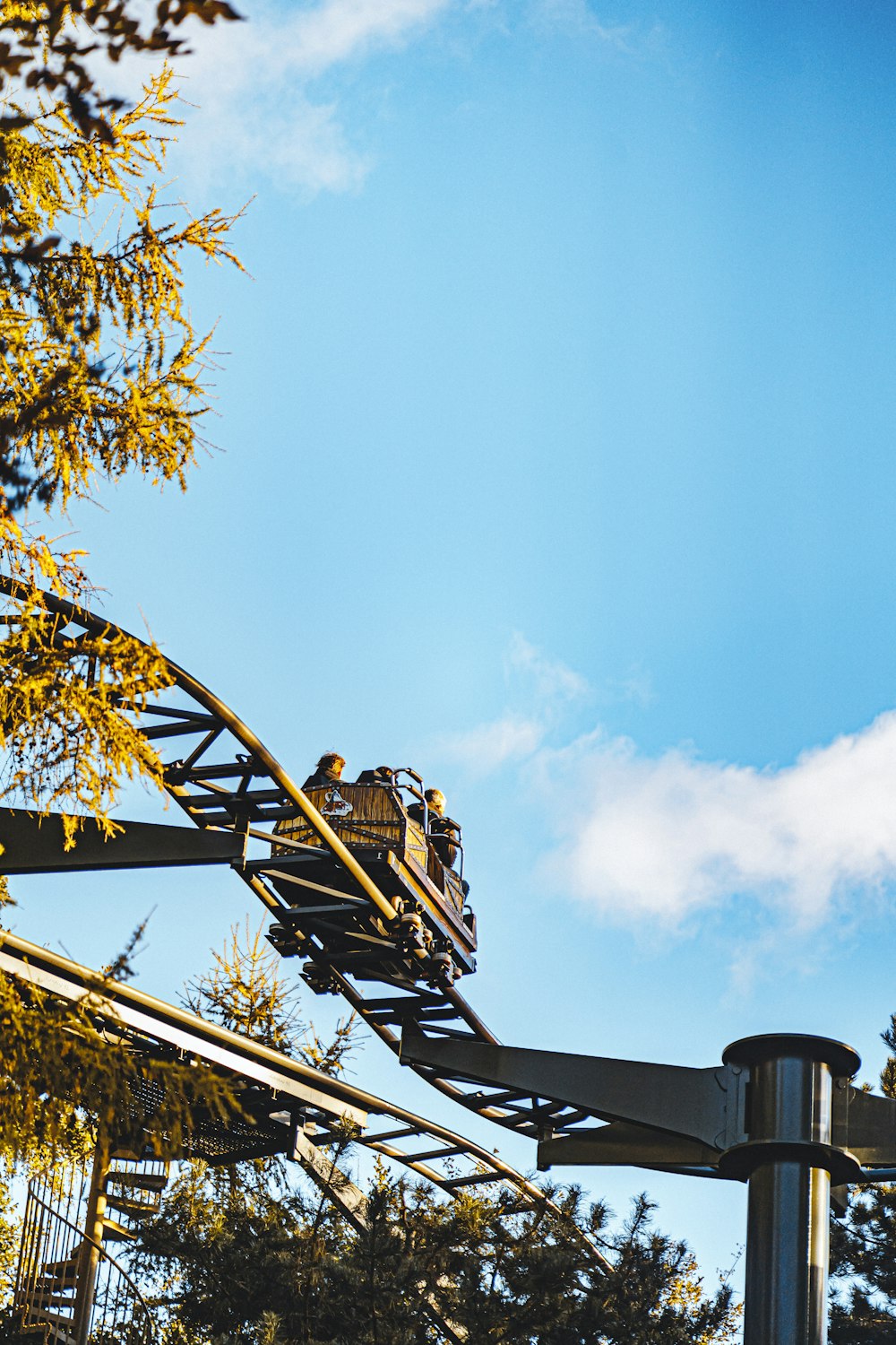 a train going down a roller coaster on a sunny day