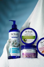 a bottle of lotion, a bottle of body scrub, and a bottle of