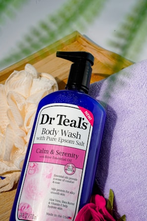 a bottle of dr teal's body wash next to a flower
