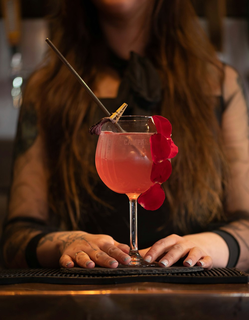 Une femme assise dans un bar avec un verre à la main
