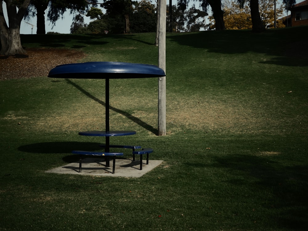 a blue picnic table and benches in a park