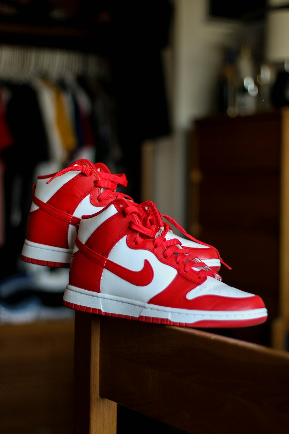 a pair of red and white sneakers on a wooden bench