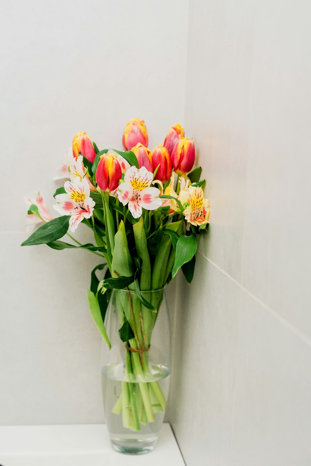 a vase filled with pink and yellow flowers