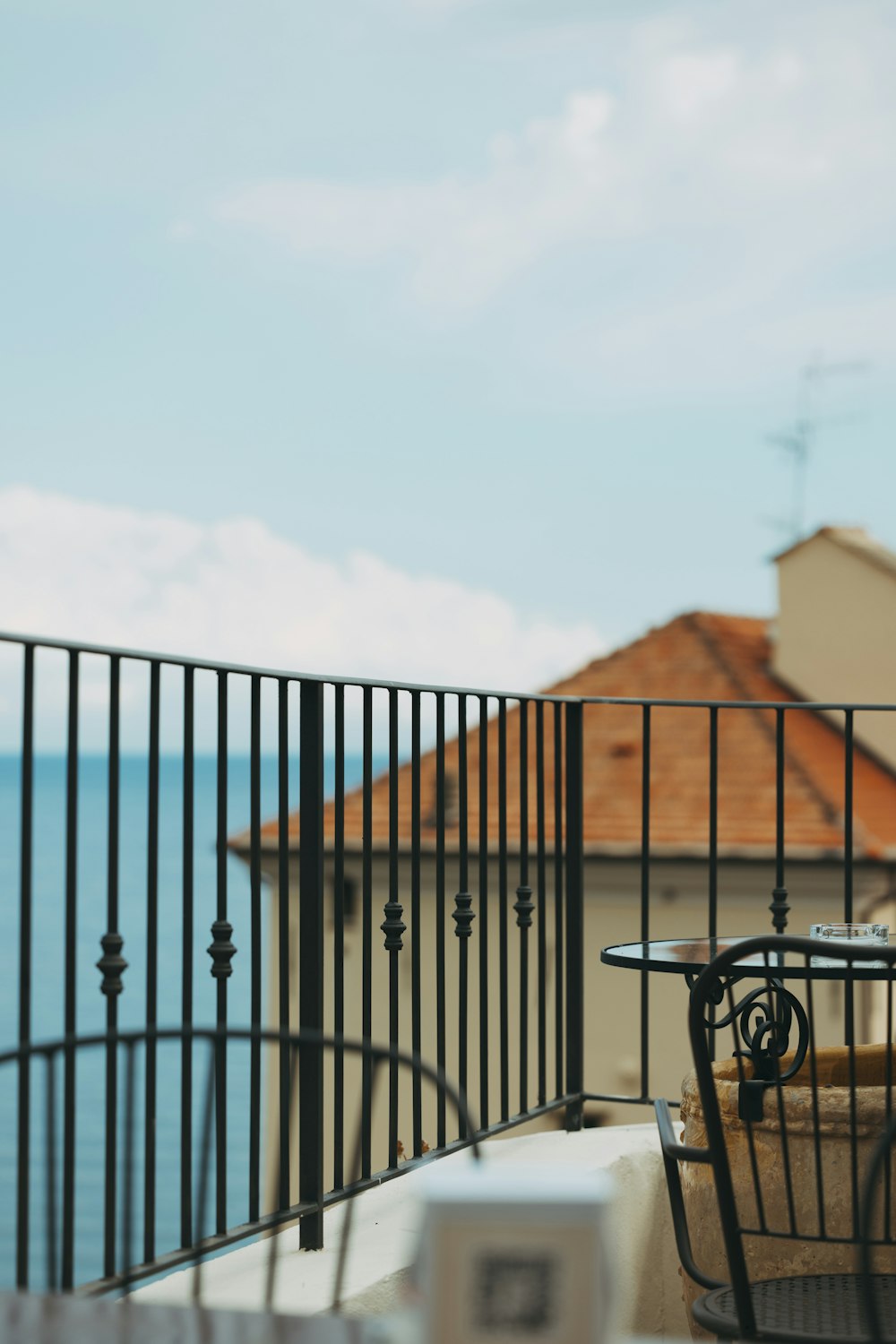 a balcony with a table and chairs overlooking the ocean